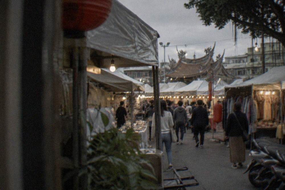 Crowded stalls and glowing signs at a Tainan night market in the evening