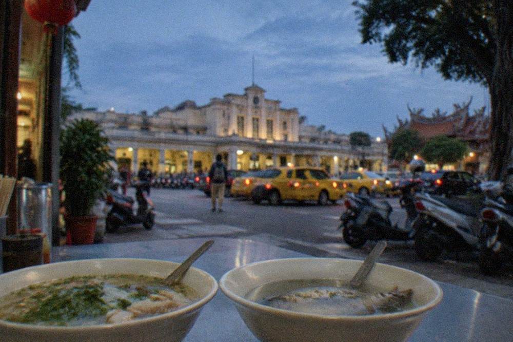 Bowls of noodle soup and milkfish soup on a counter at a small Tainan eatery