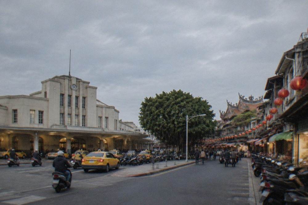 A historic Tainan street at dusk with lanterns hanging over old shopfronts