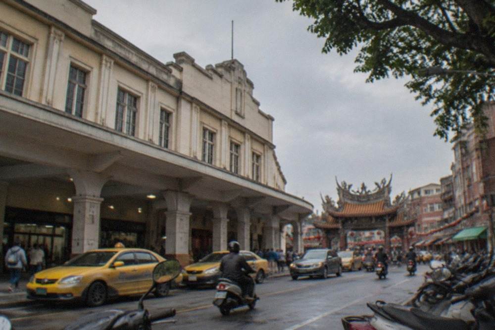 A historic Tainan street with old brick buildings and a temple gateway in daylight