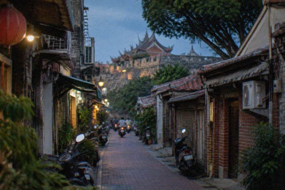 Anping old street with low traditional buildings and a stone fort wall in the background