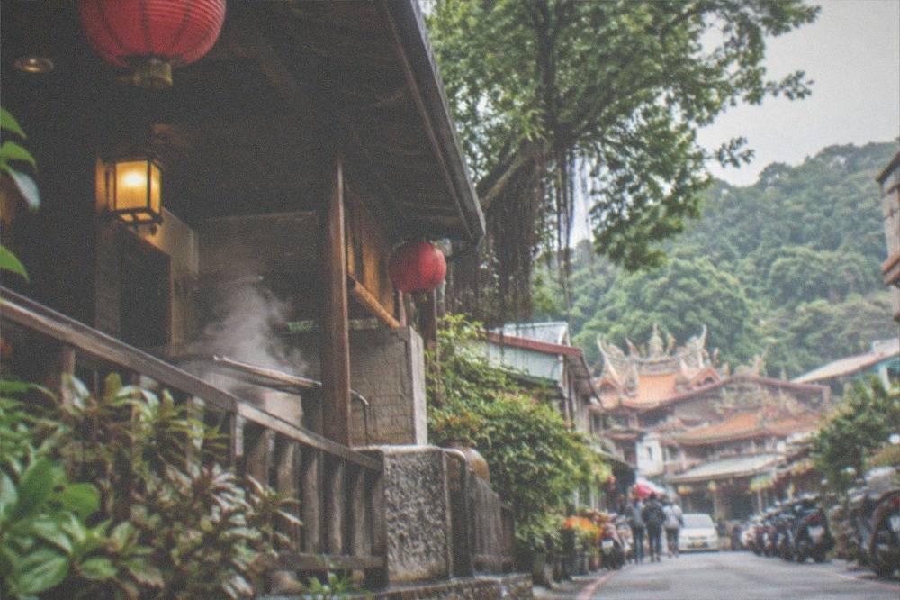 A hot spring bathhouse terrace overlooking forested slopes