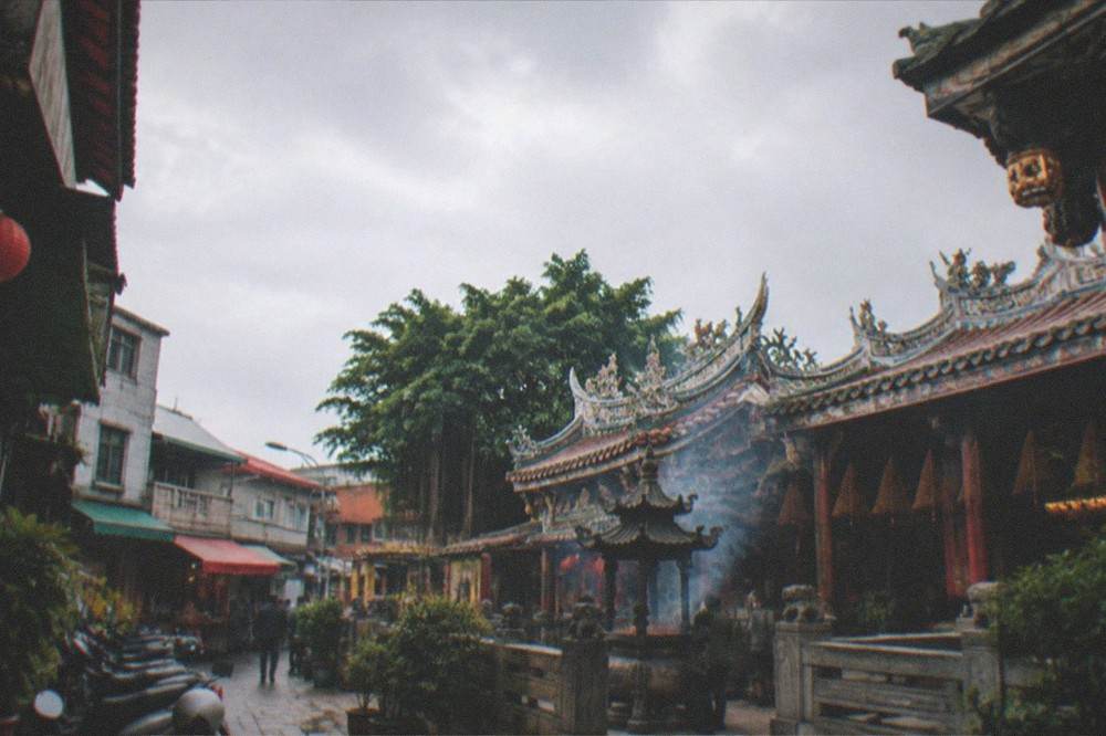 Temple courtyard with incense coils and tiled roofs in central Tainan
