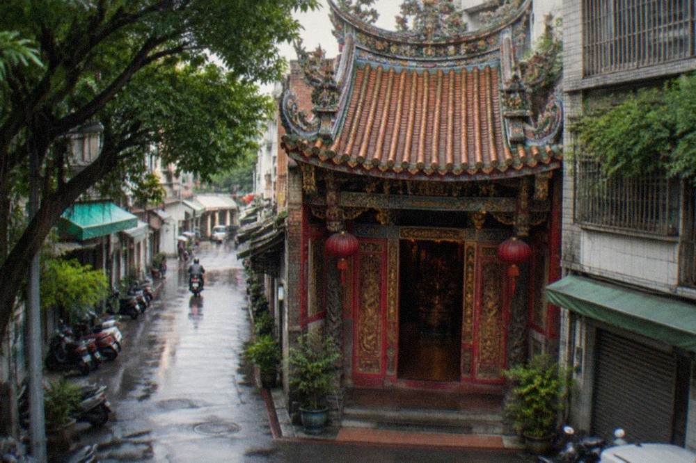 Carved wooden temple doors with red paint and gold detail in Tainan