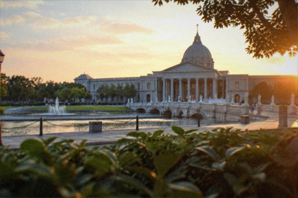 A wide view of the museum facade at dusk with warm lighting on the columns