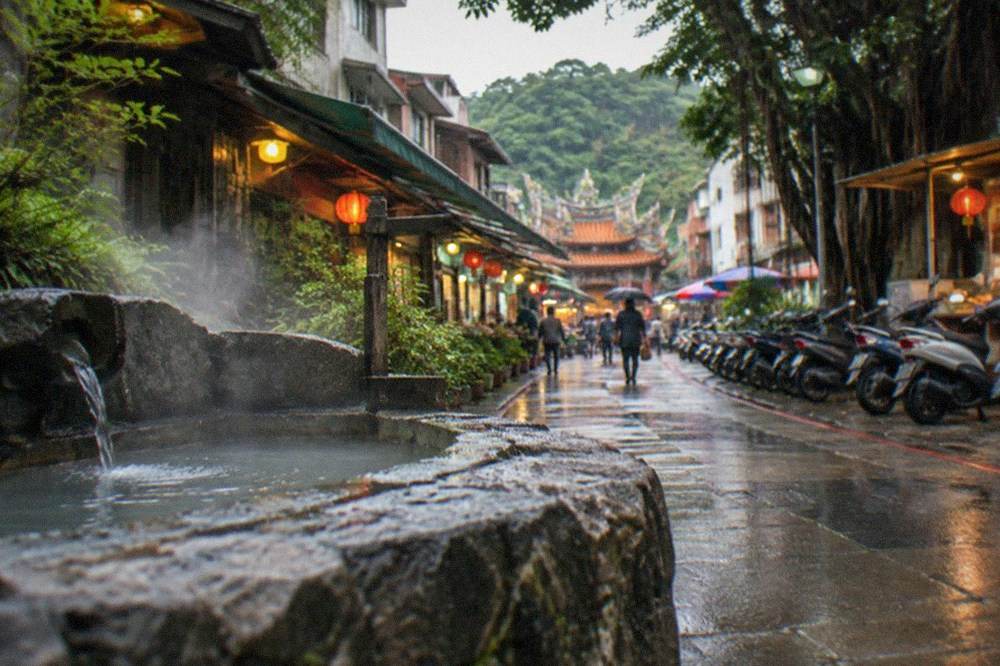 A covered pedestrian street of spa hotels and food stalls on a hillside at dusk