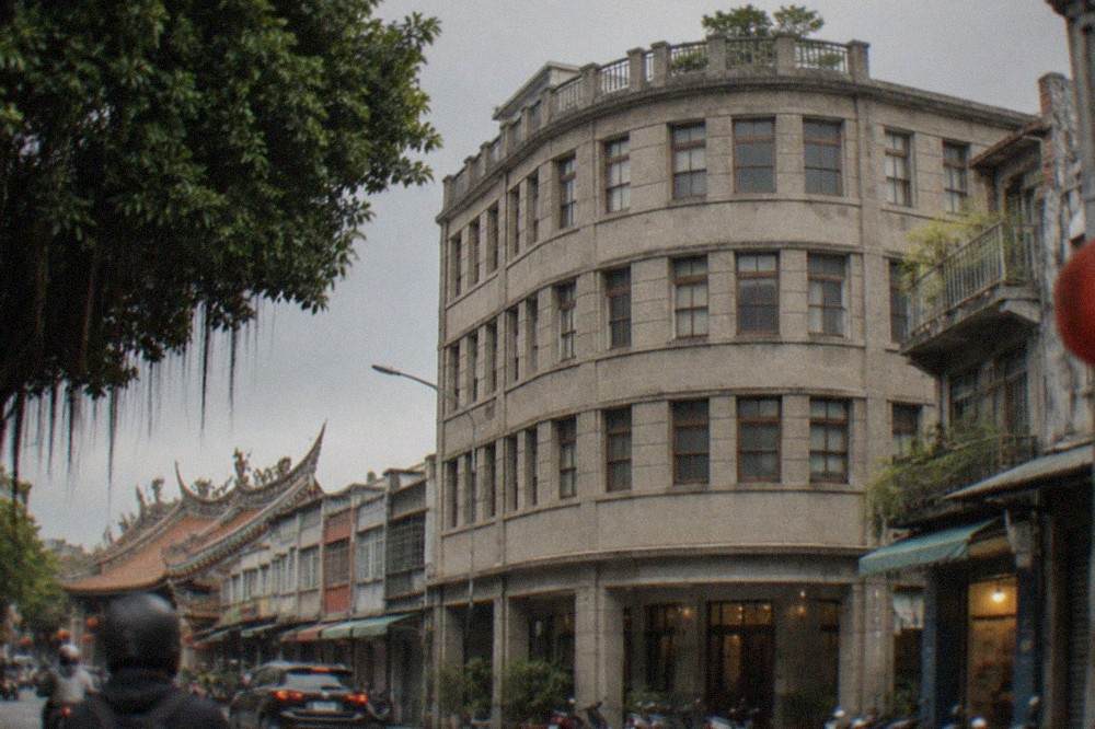 A close view of the restored department store's upper floors with original window frames and a curved corner