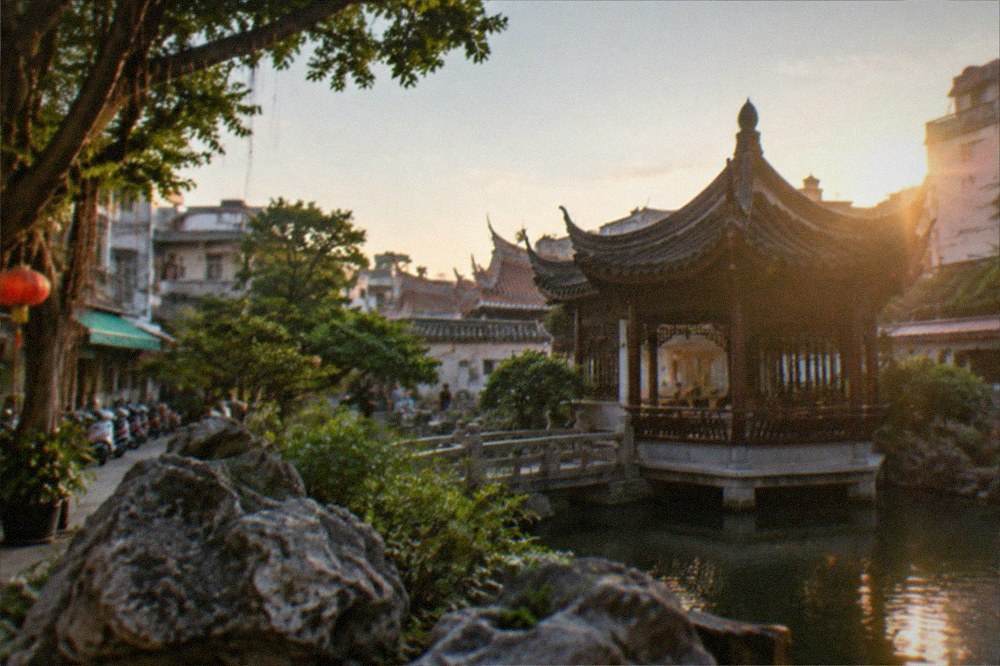A pavilion roofline against an evening sky in a Tainan garden