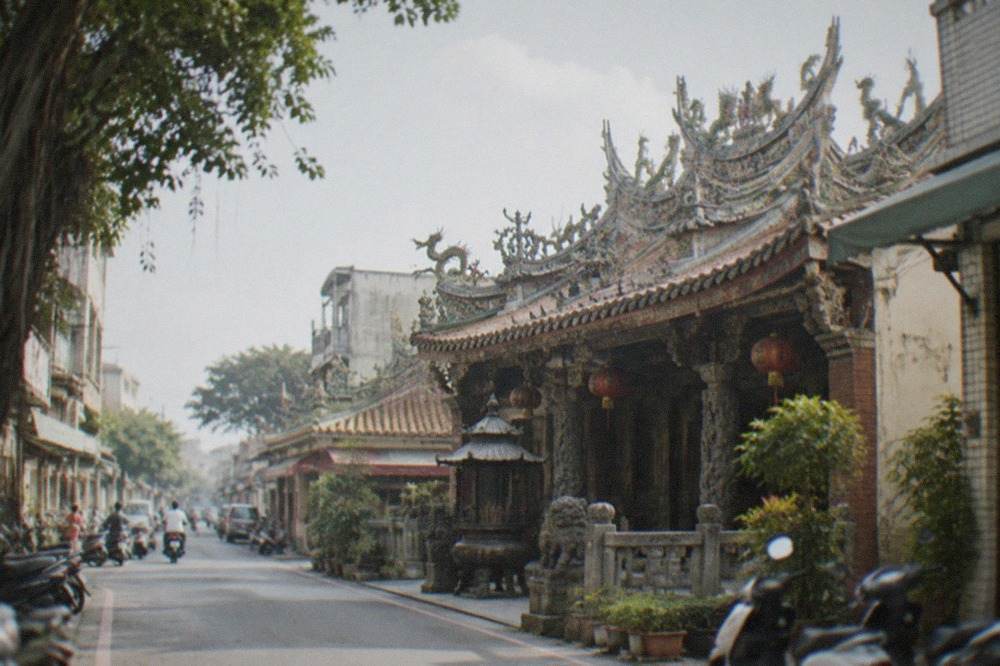 A historic Taiwanese temple facade with carved roof decorations in a small town street