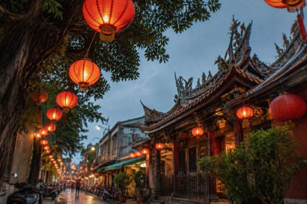 Lanterns glowing above a narrow old street at night