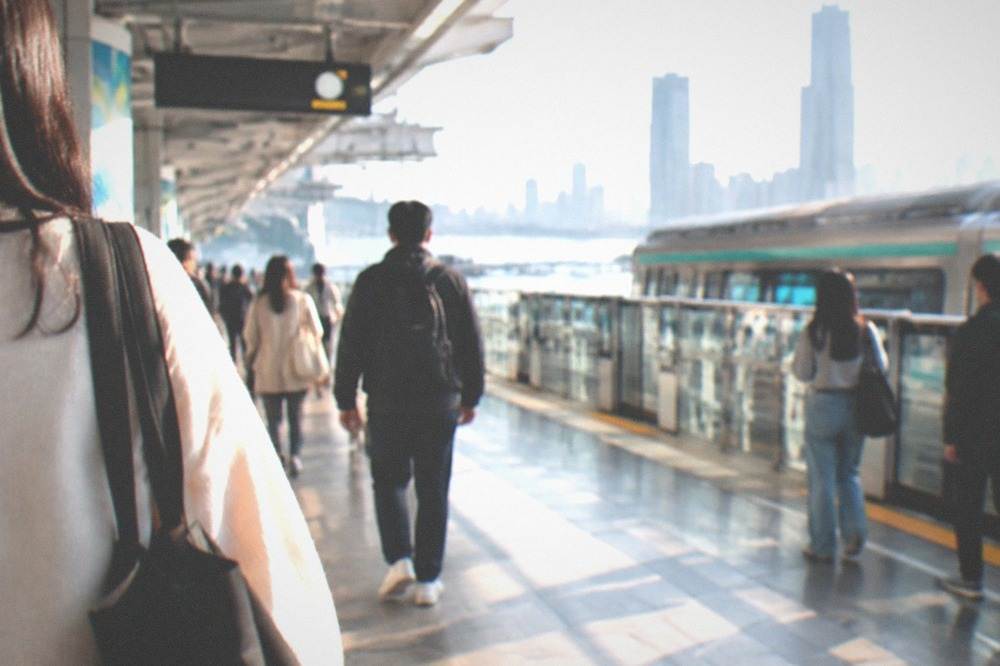 Commuters passing through a bright modern metro station in Kaohsiung