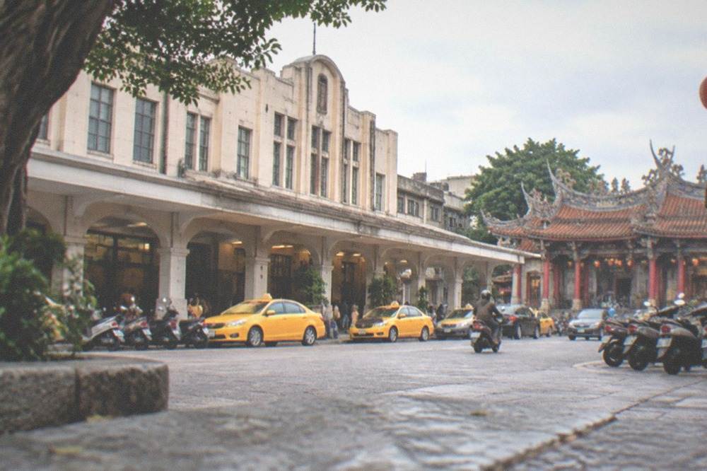 A historic Tainan temple courtyard with red columns and stone paving in morning light