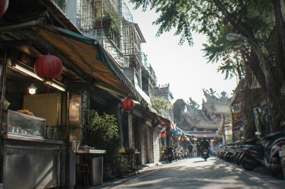 A narrow food lane in Tainan's West Central District lined with small snack shops and hanging signs