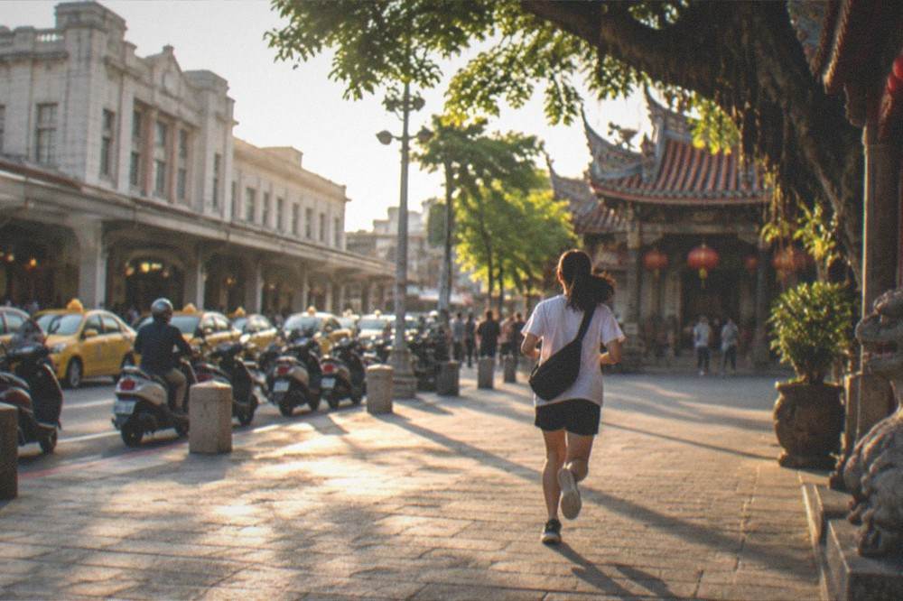 A quiet temple courtyard in Tainan with stone paving and ornate roof detail in warm light