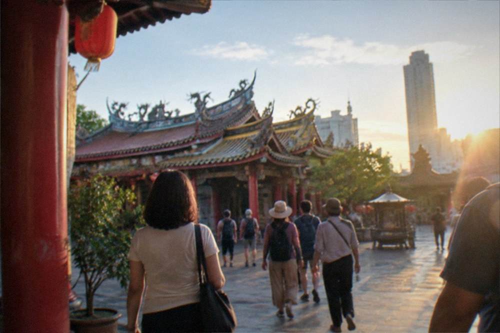 A guided tour group walking through a temple courtyard in Tainan