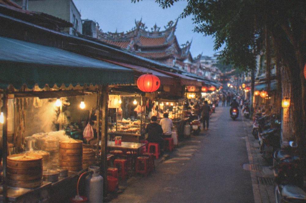A day-to-evening view of a Tainan old street with lanterns and food stalls