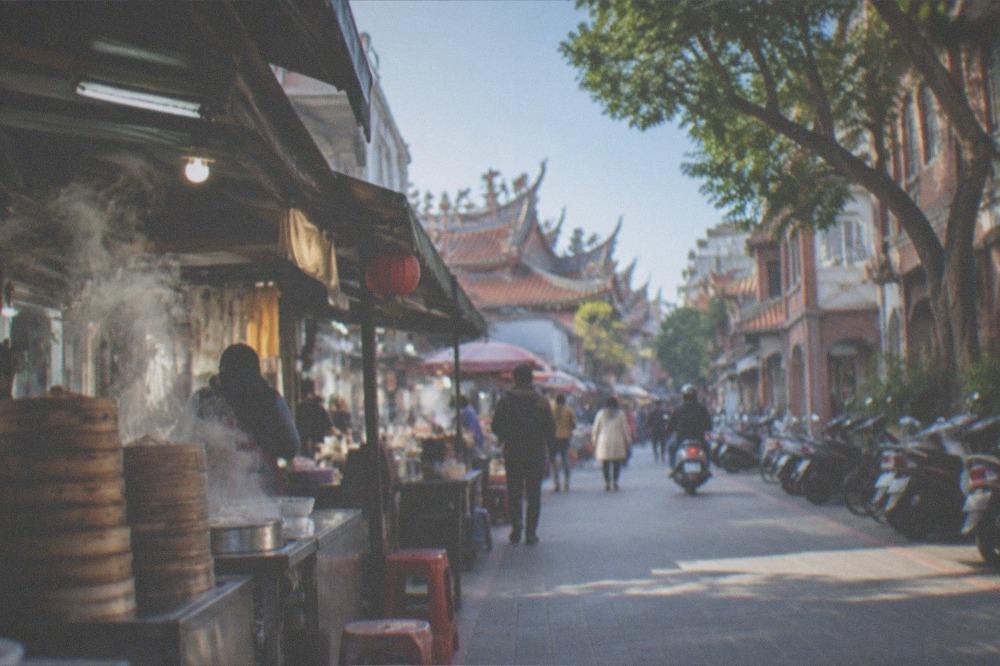 A sunny winter morning on a Tainan old street with red-brick facades and temple rooftops