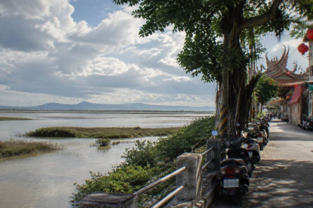 Wide view of Qigu wetlands with fish ponds and distant mountains