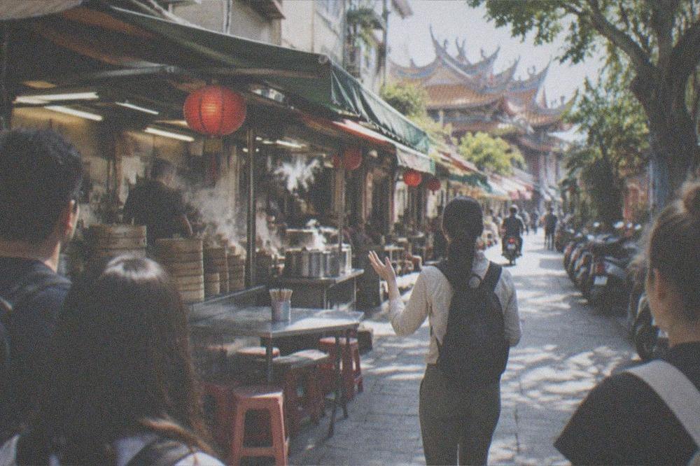 A guide speaking to a small group of travelers on a Tainan old street lined with shops