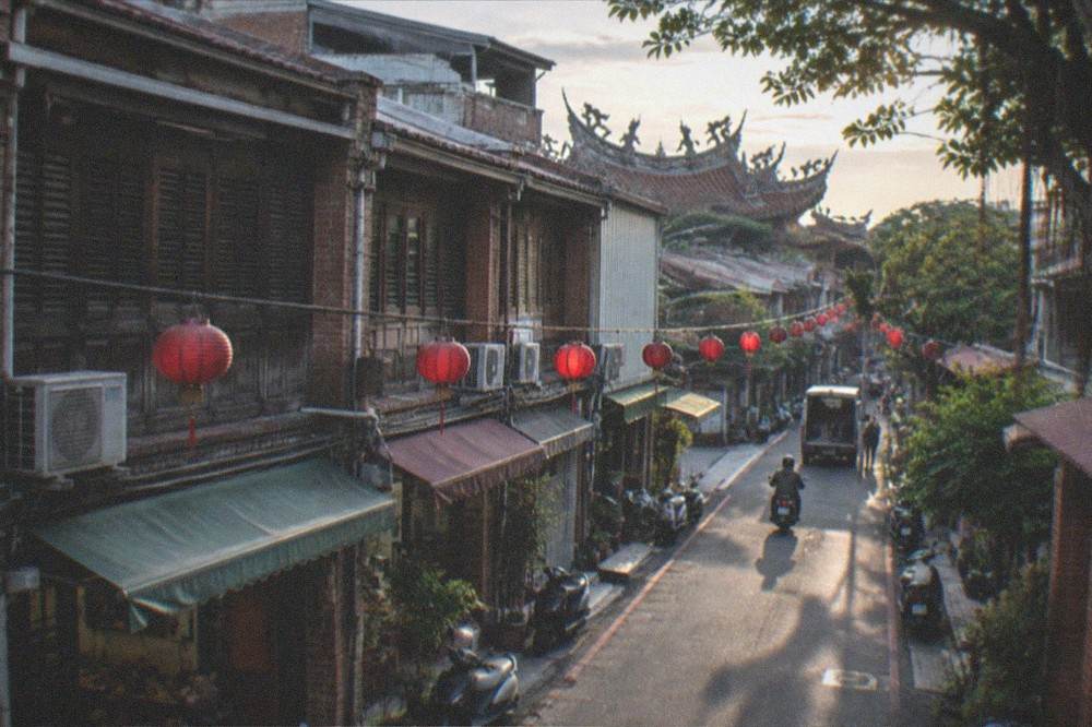 A temple roof line with curved eaves and decorative figures against an evening sky