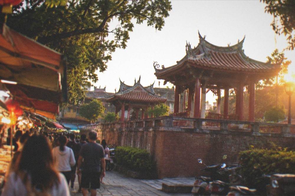 A busy evening food street with lit stalls and crowd movement