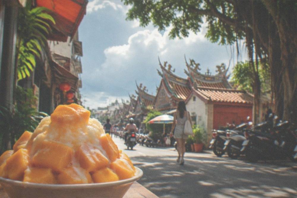A tall plate of mango shaved ice with condensed milk drizzled over fresh mango cubes