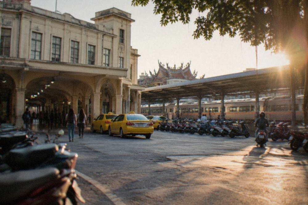 Trains waiting at the platforms of Tainan Railway Station under a long canopy roof