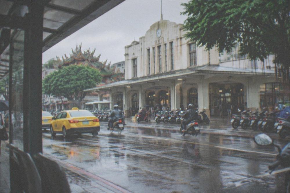 A covered bus stop in Tainan with rain falling beyond the shelter