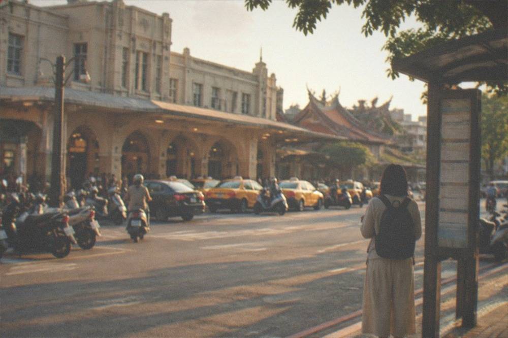 A traveler waiting at a Tainan bus stop with a printed schedule
