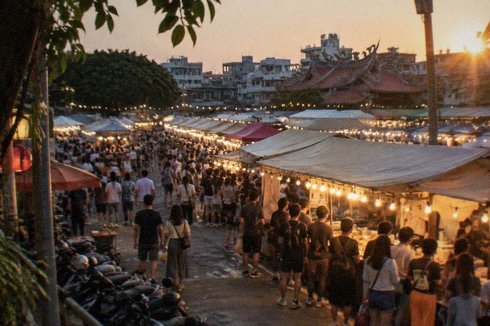 A night market stall glowing under string lights with a queue of customers