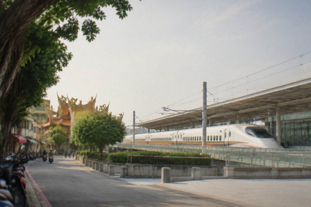 A white high speed rail train stopped at a modern station platform