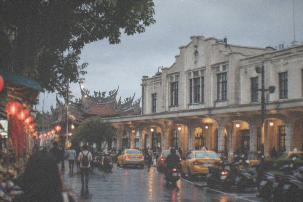 Visitors walking through a lantern-lit Tainan old street in the early evening