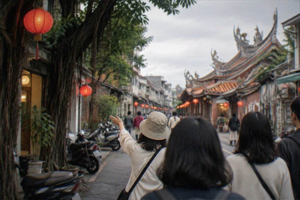 A guide leading a small group down a lantern lit old street in Tainan