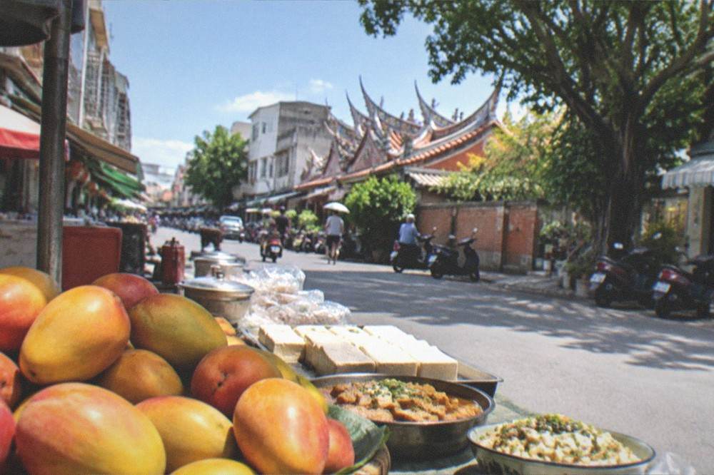 Fresh mangoes and tofu dishes on a market table in Tainan