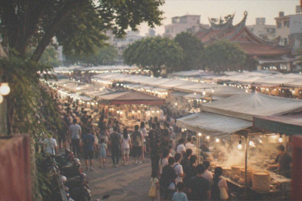 A night market stall with steaming baskets and a queue of families waiting for food