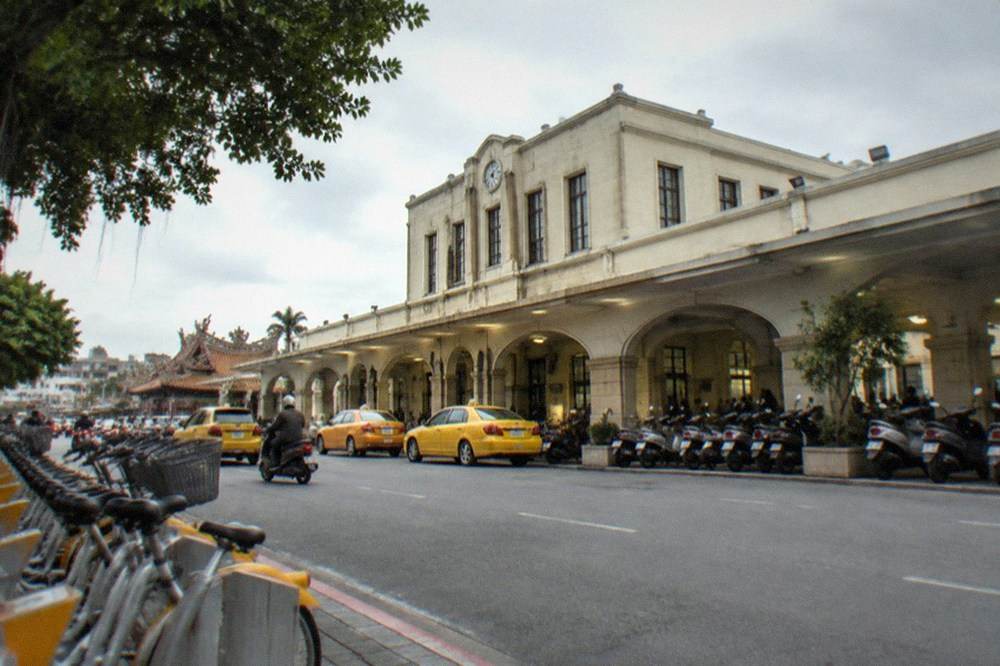 A row of rental bicycles docked at a station next to a city sidewalk