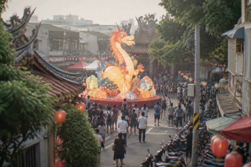 A large crowd viewing a giant illuminated festival lantern display in a Taiwanese city square