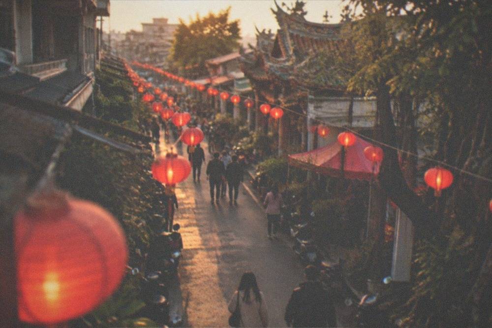 People in light jackets walking among glowing lanterns at an evening festival in Taiwan