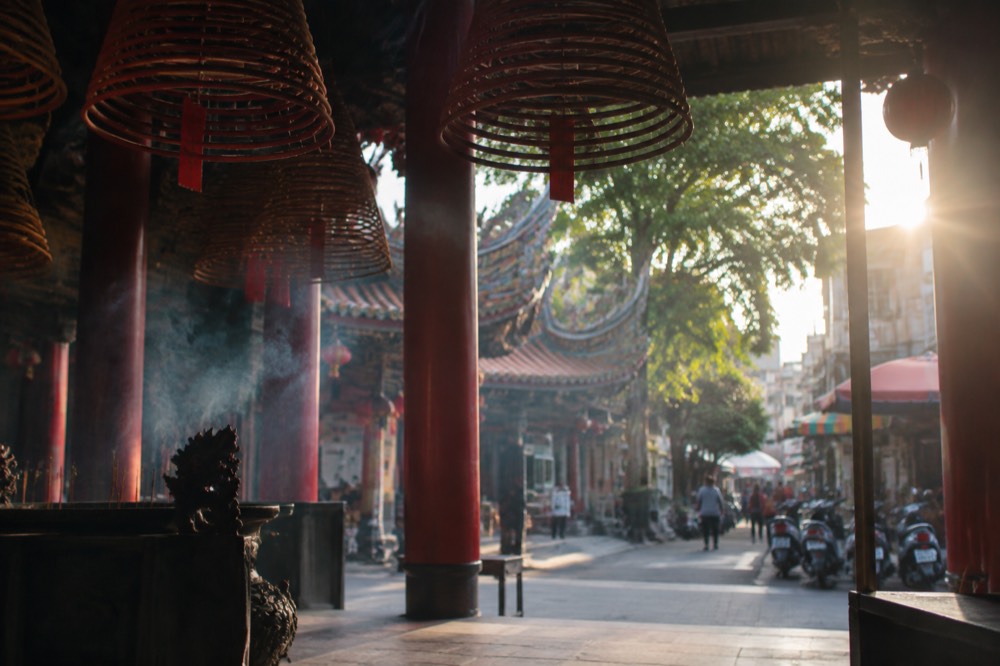 Incense coils hanging under the ceiling of a busy Tainan temple hall