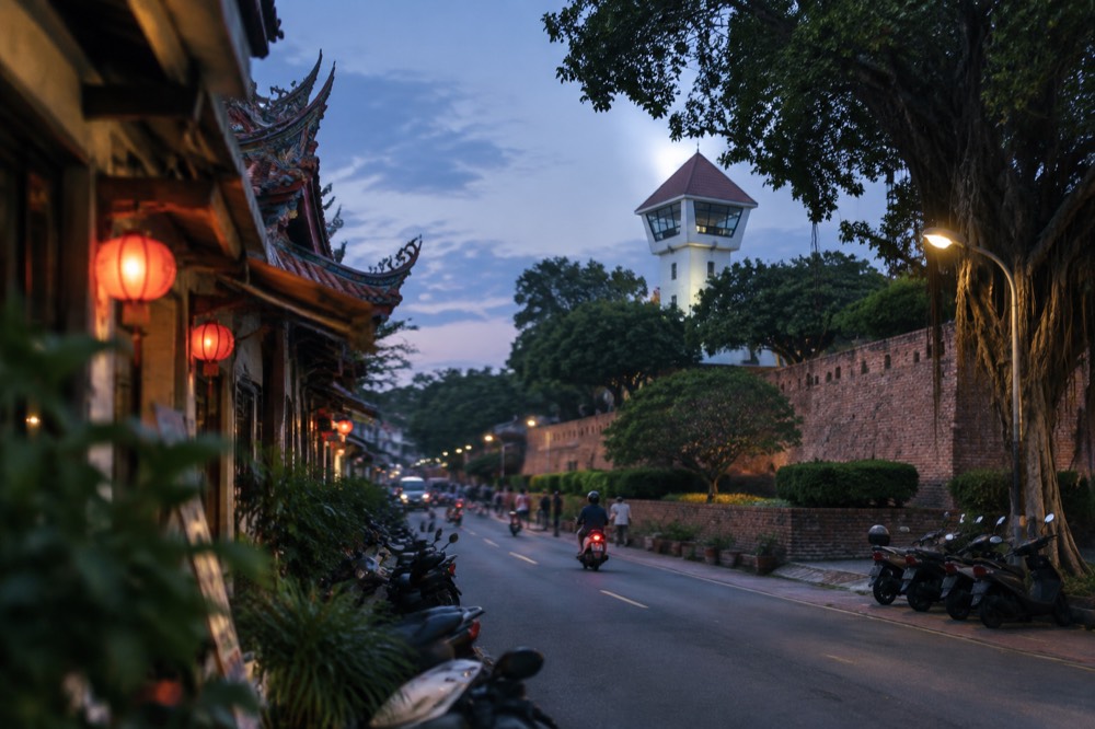 The brick ramparts of Anping Old Fort with the white lookout tower above the treeline