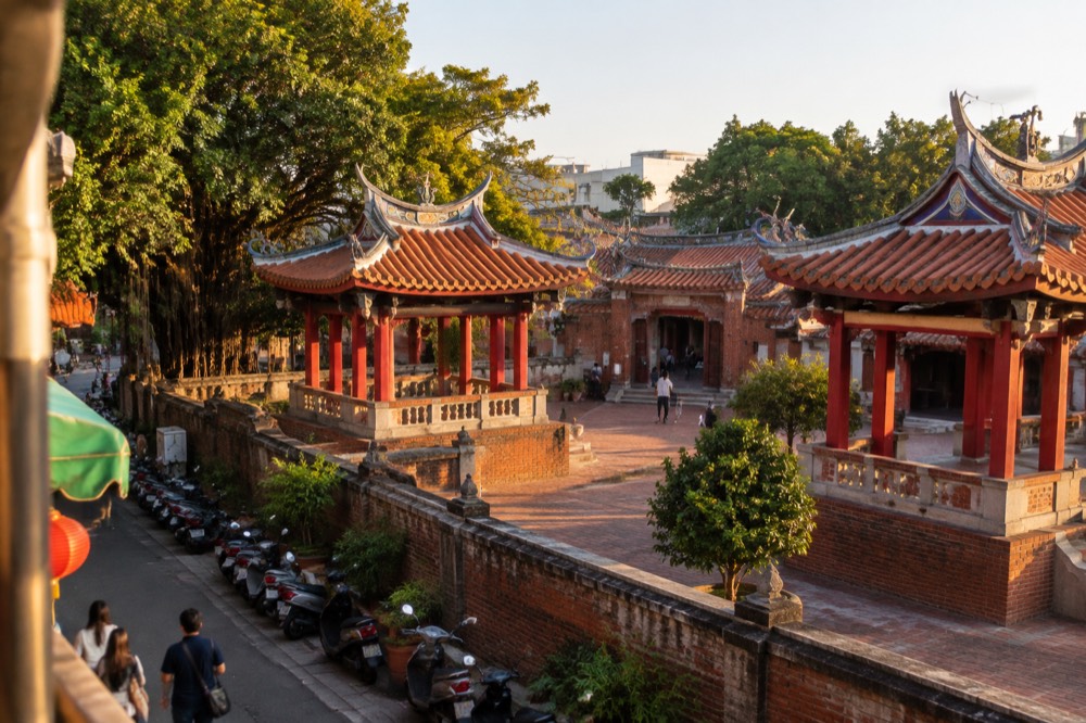 Historic red-brick gateway and courtyard of an old Tainan temple under a clear sky