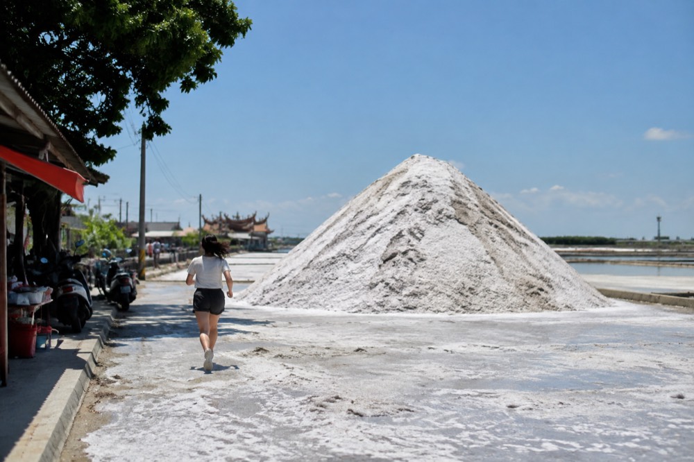 White salt mountain rising above the flat Qigu coastal landscape